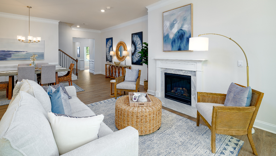 Open living room with wood floors, three windows, and fireplace