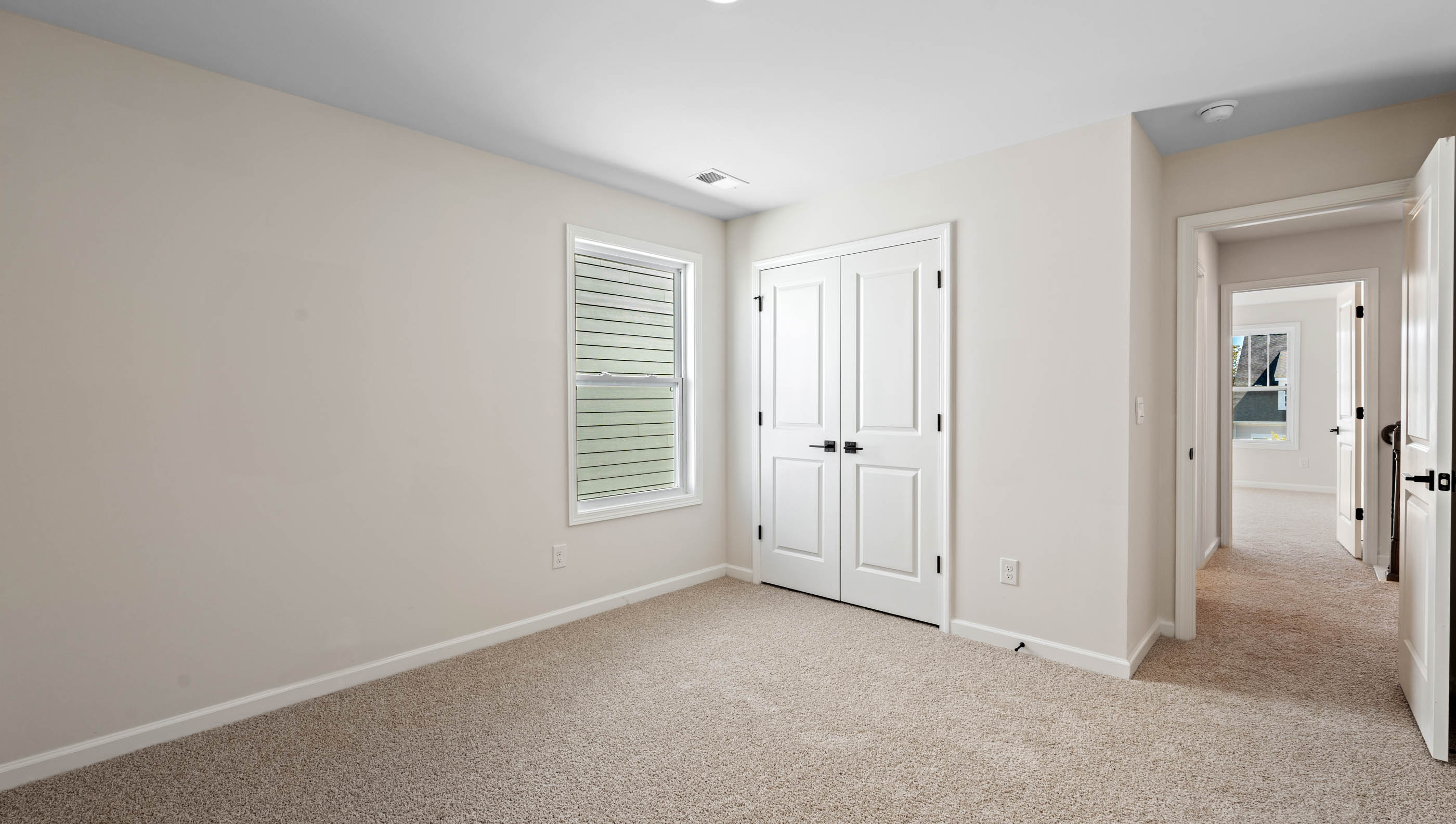 Carpeted bedroom with three large windows