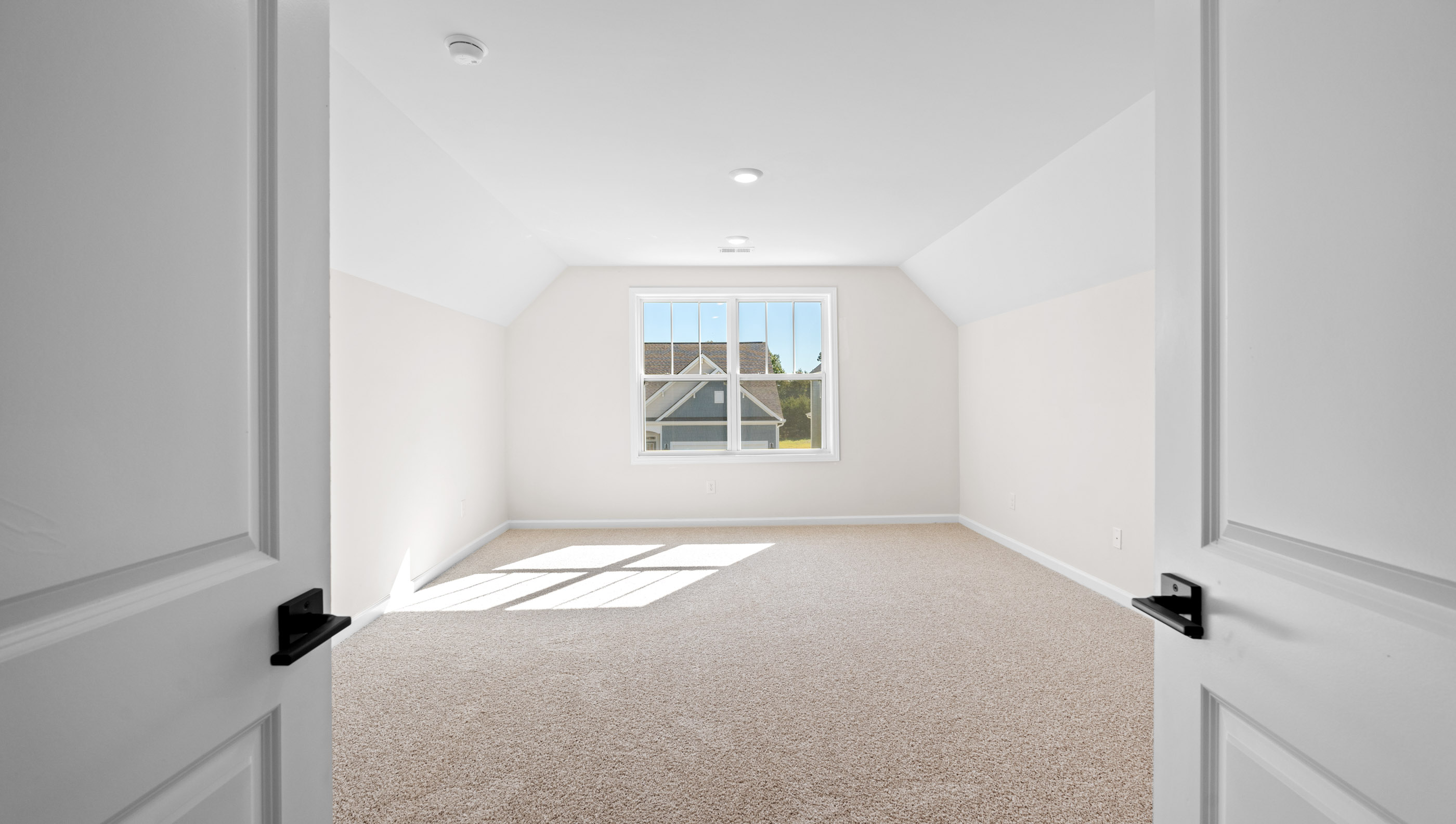 Primary suite carpeted with two windows