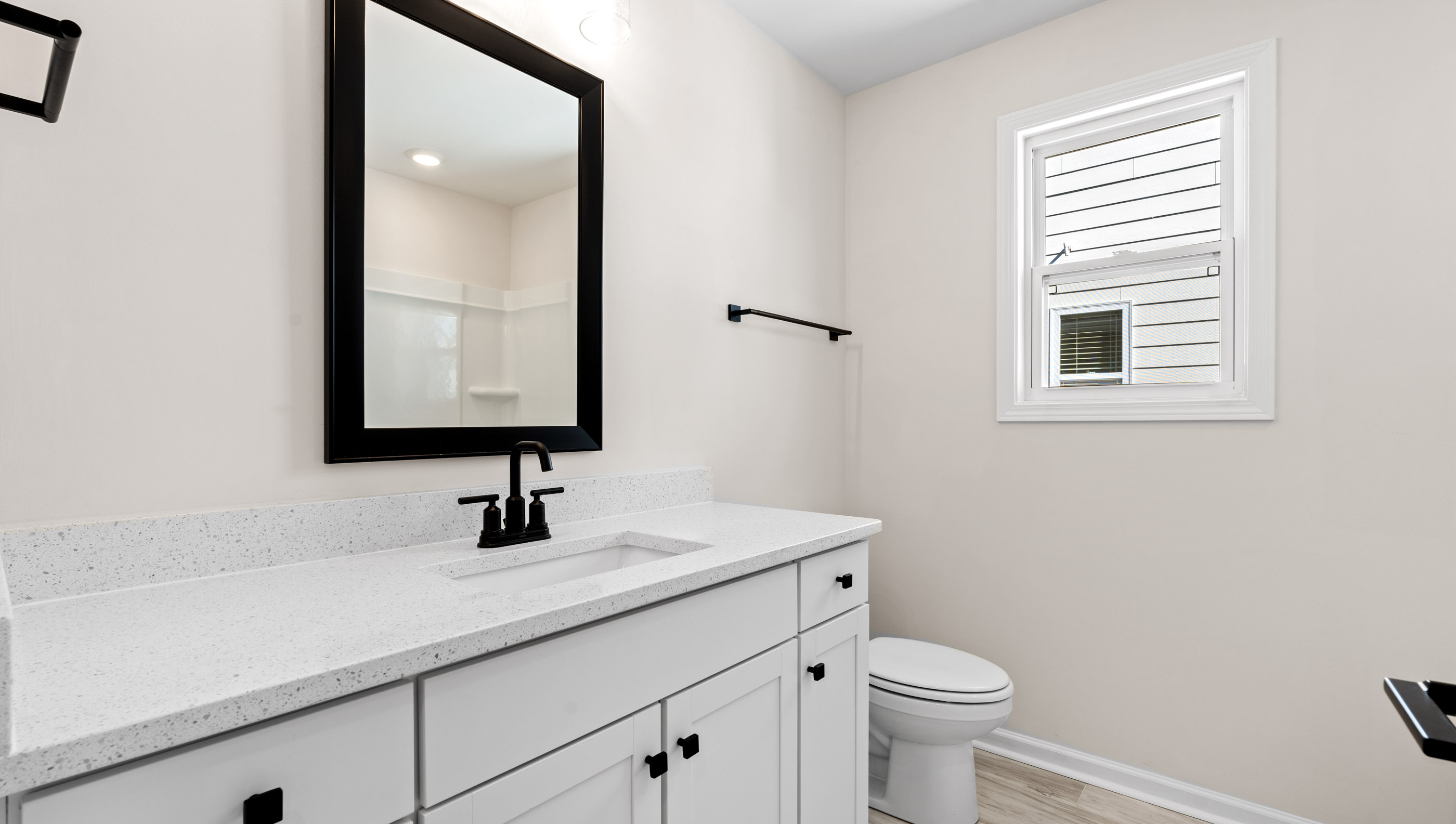 Bathroom with double sinks, white cabinets and bathtub