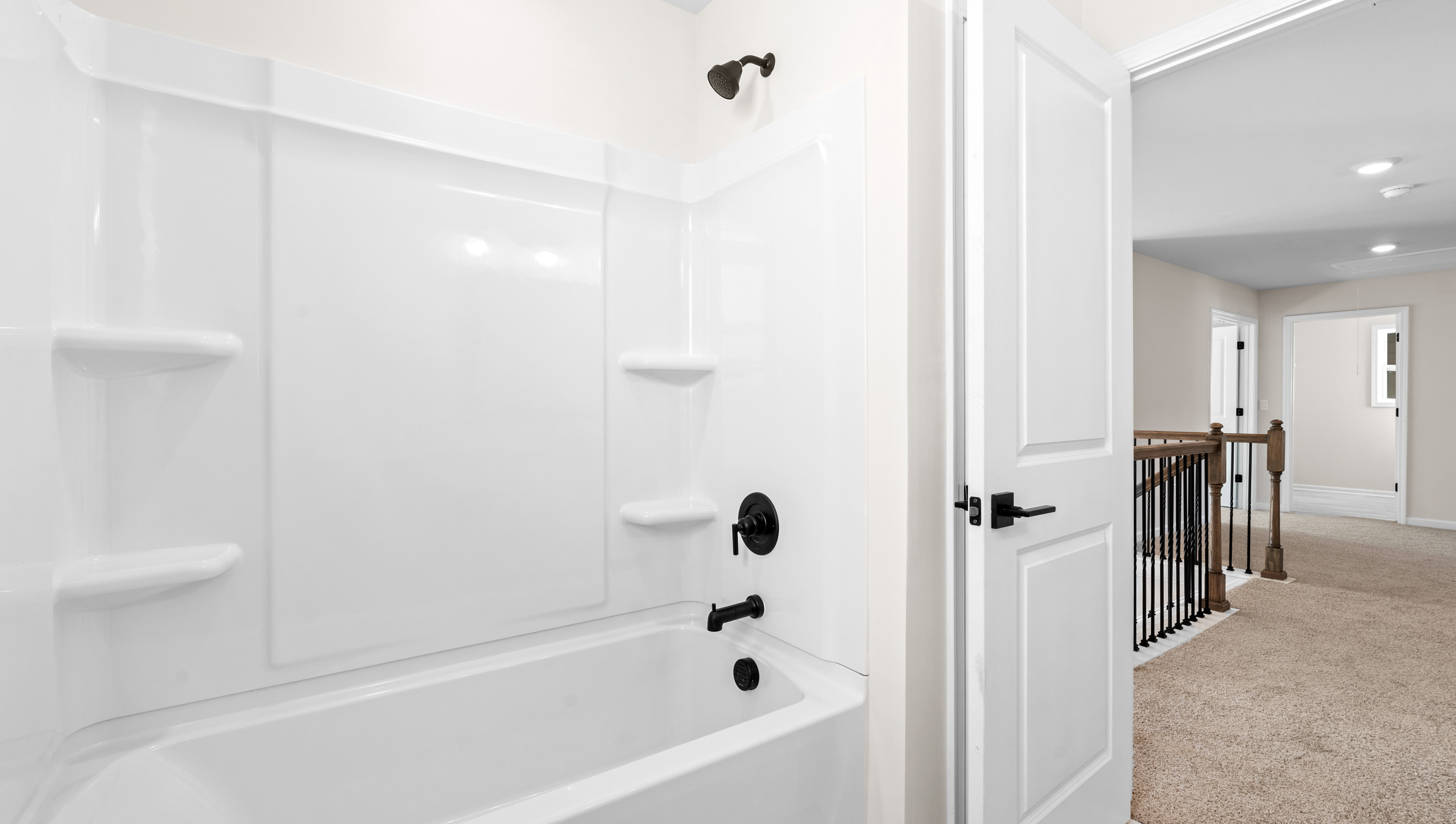 Bathroom with double sinks, white cabinets and bathtub