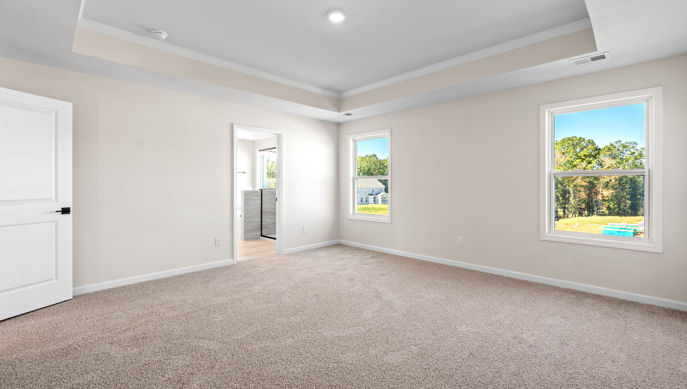 Primary suite carpeted with two windows