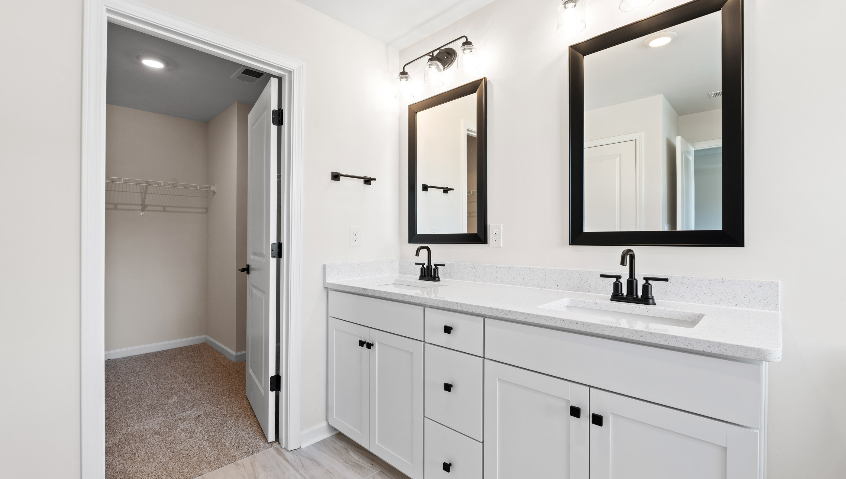 Primary bathroom with white cabinets, bathtub, and glass door shower