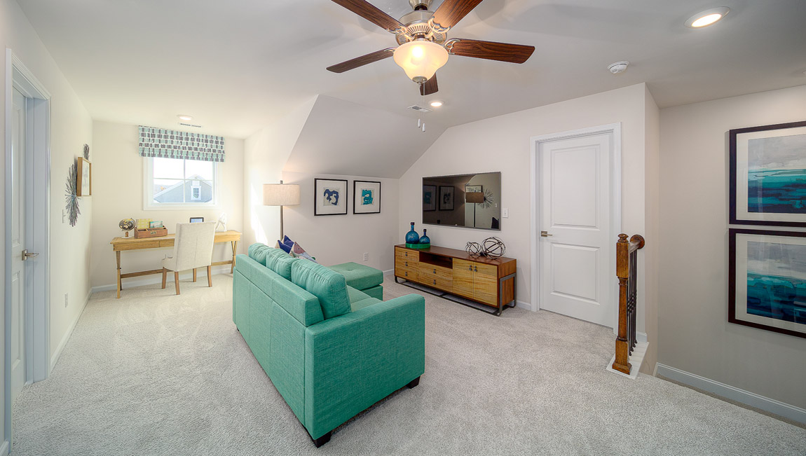 Upstairs carpeted loft space with small window