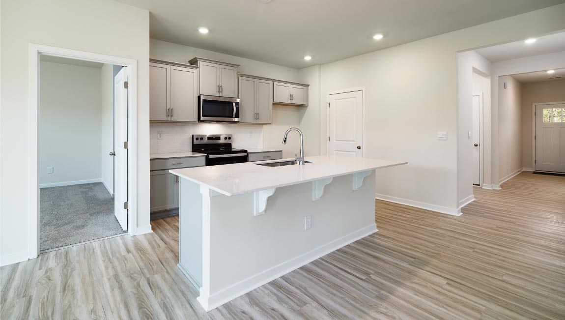 Kitchen and island with white cabinets, breakfast area at island, and stainless steel appliances