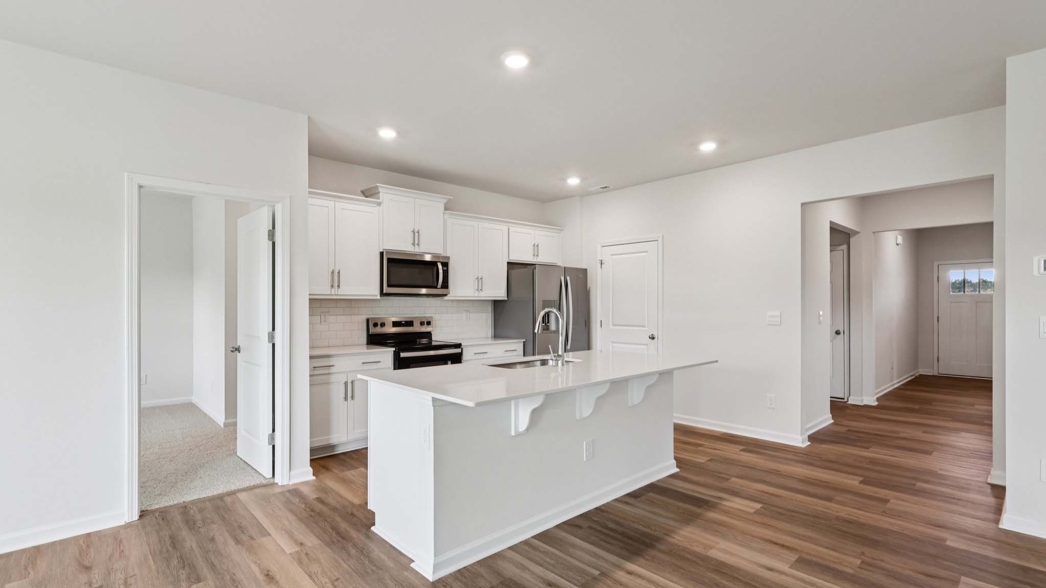 Kitchen and island with white cabinets, breakfast area at island, and stainless steel appliances