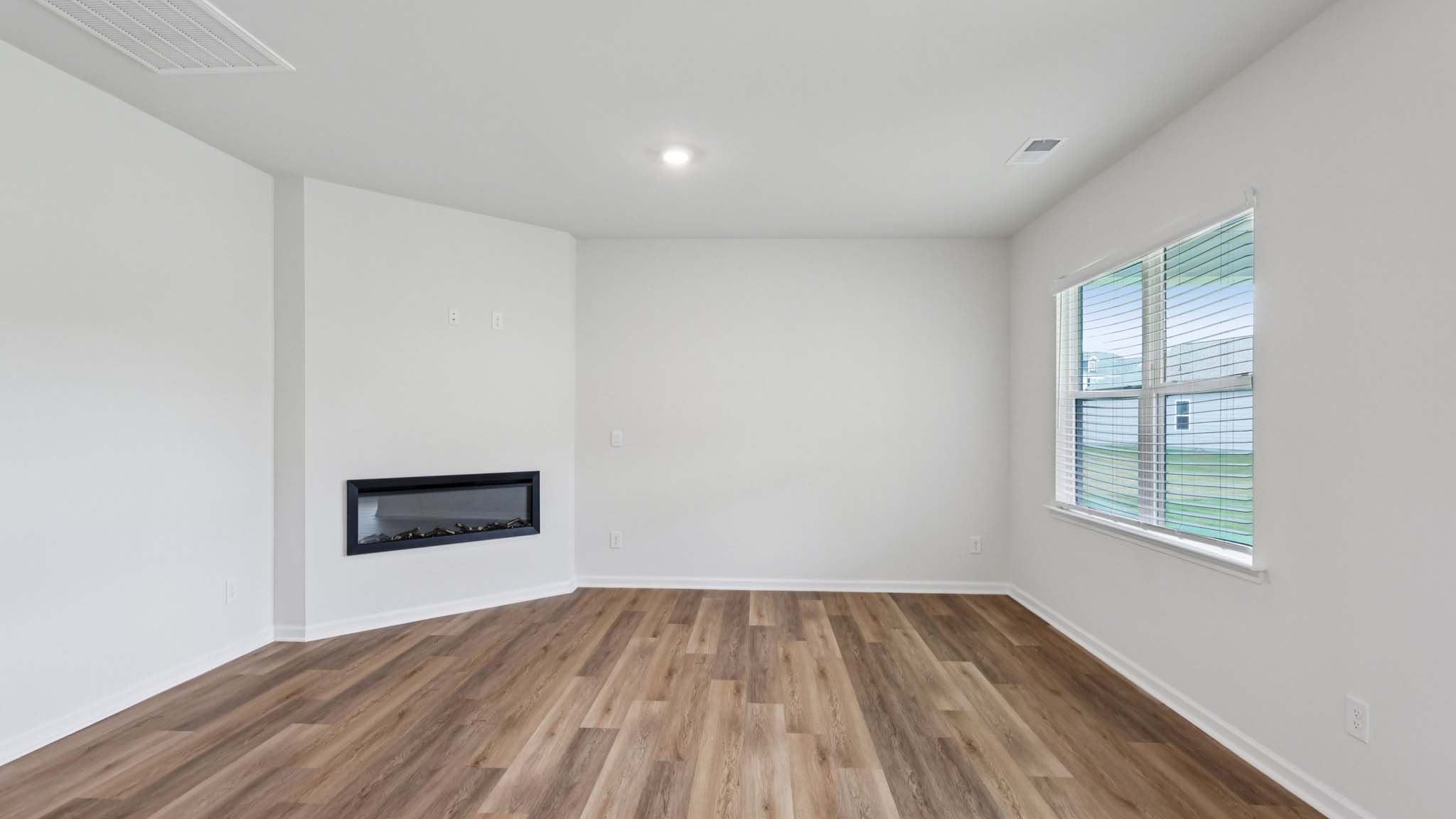 Open living room with ceiling fan and large window, kitchen and dining room in view