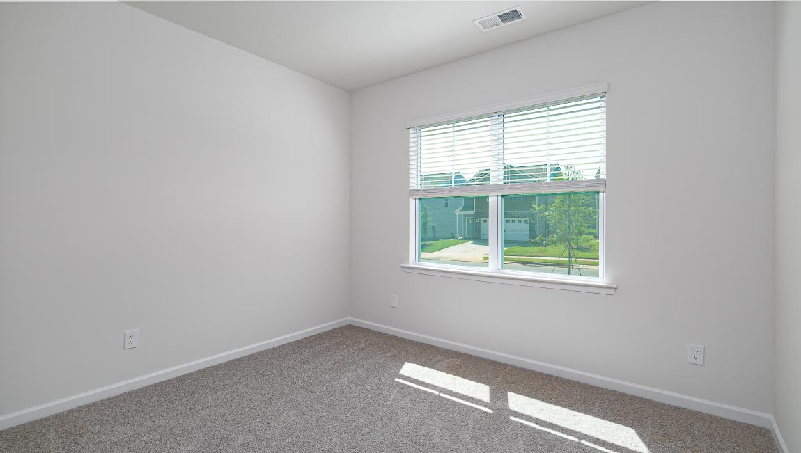 Carpeted bedroom with windows