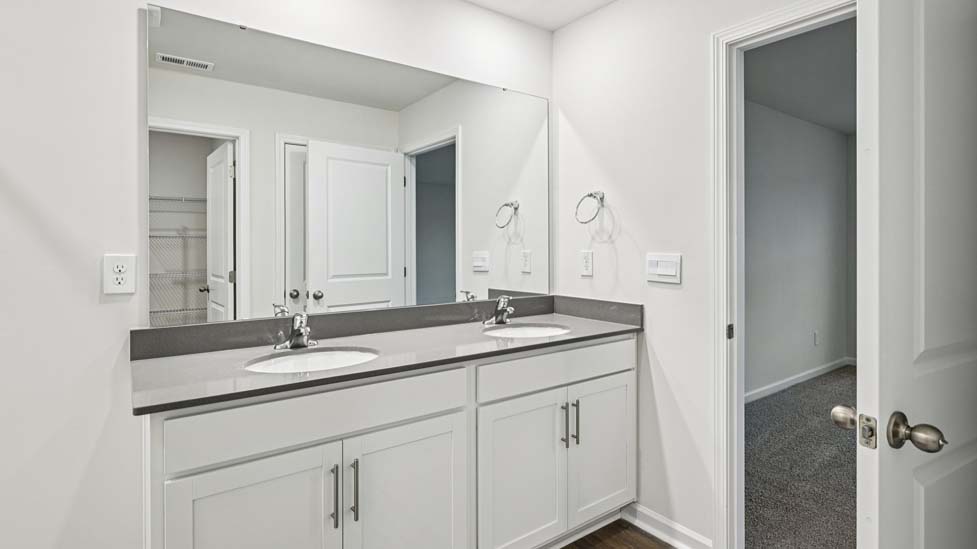 Primary bathroom with double vanity and glass door shower
