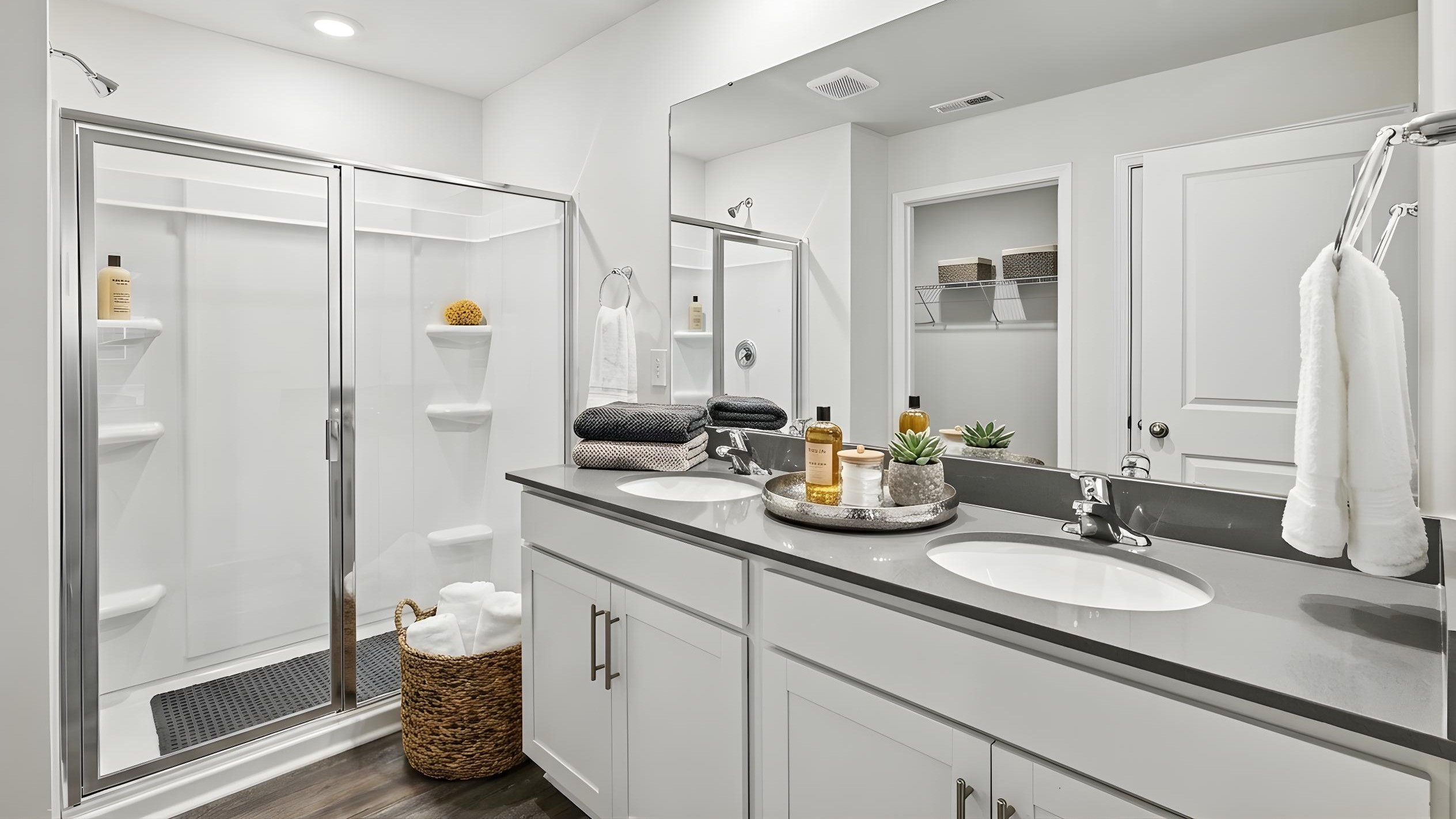 Primary bathroom with double vanity and glass door shower