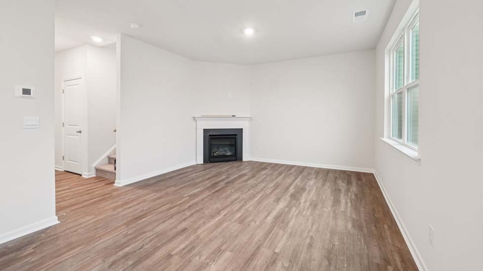 living room with vinyl flooring, electric fireplace and large window