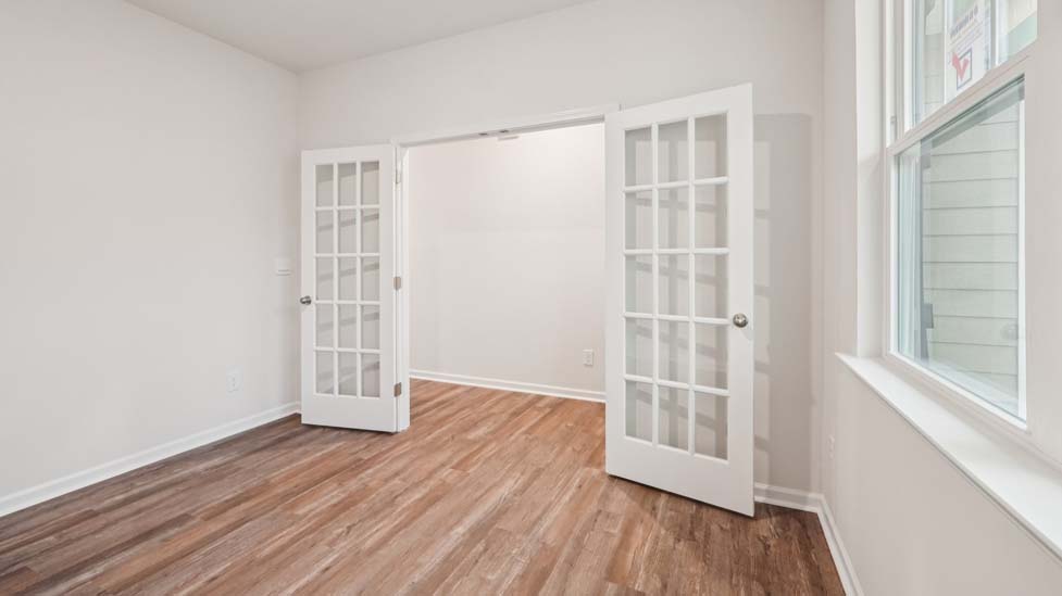 Flex space with hard wood flooring, large window and french doors