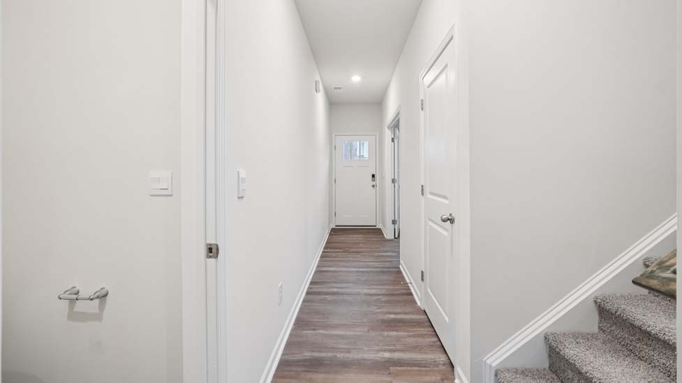 Welcoming foyer from front door with view of hallway and flex space