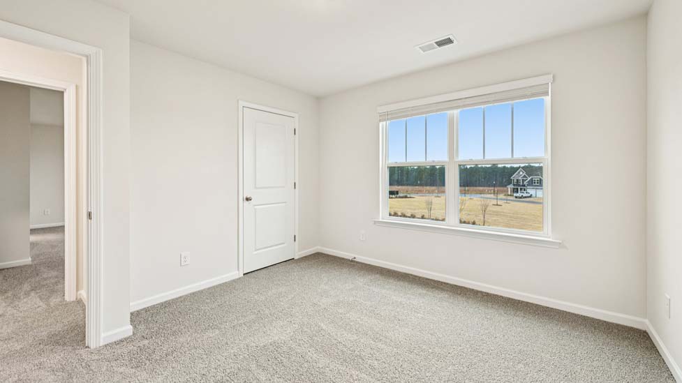 Carpeted bedroom with large window