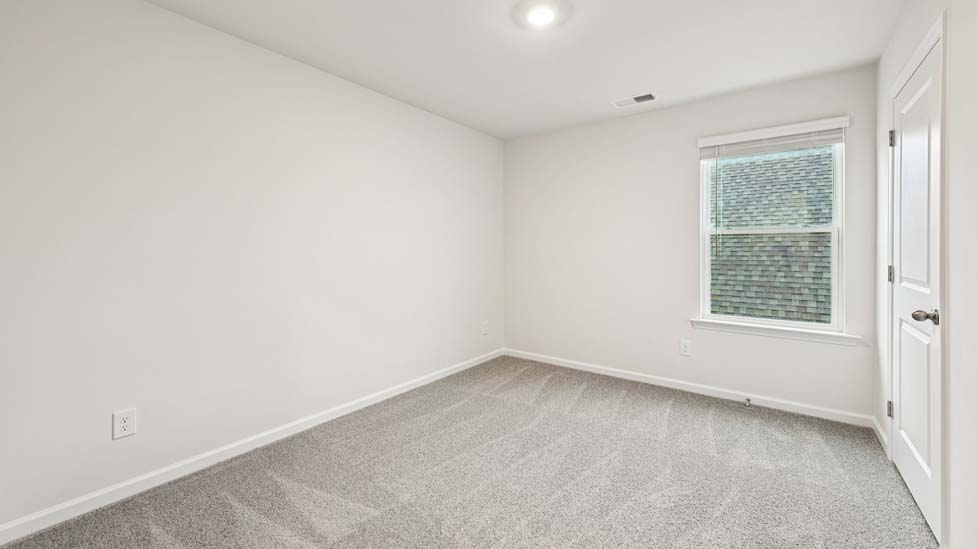 Carpeted bedroom with large window