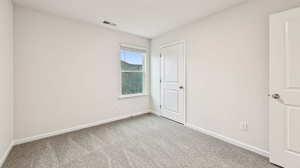 Carpeted bedroom with large window
