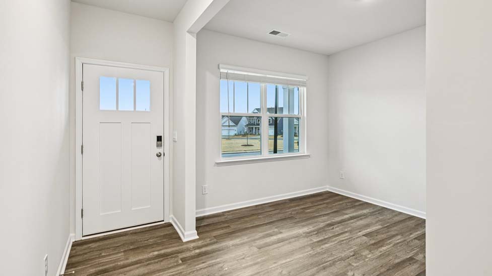 Welcoming foyer from front door with view of hallway and flex space