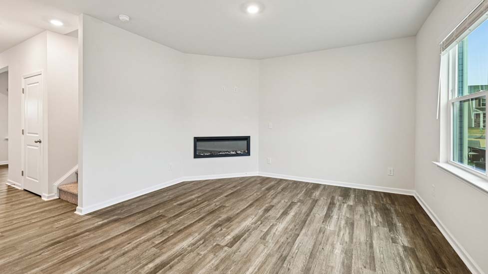 living room with vinyl flooring, electric fireplace and large window