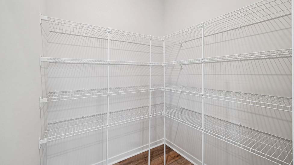 kitchen and island with white cabinets, wood floors and stainless steel appliances