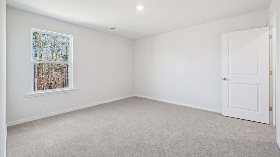carpeted bedroom with large window