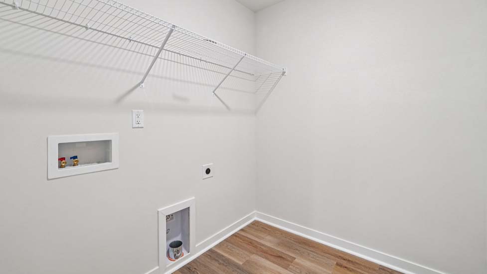 Laundry room with built in hanger and storage racks above machines