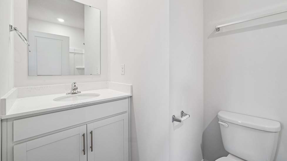 bathroom with white cabinets and counters, and bathtub
