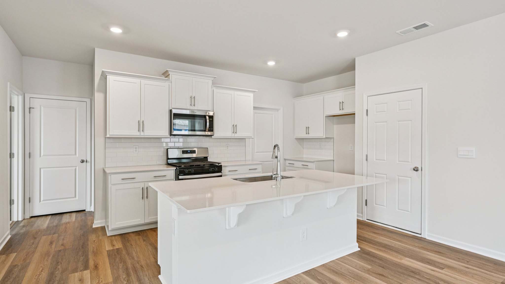 Kitchen and island with stainless steel appliances