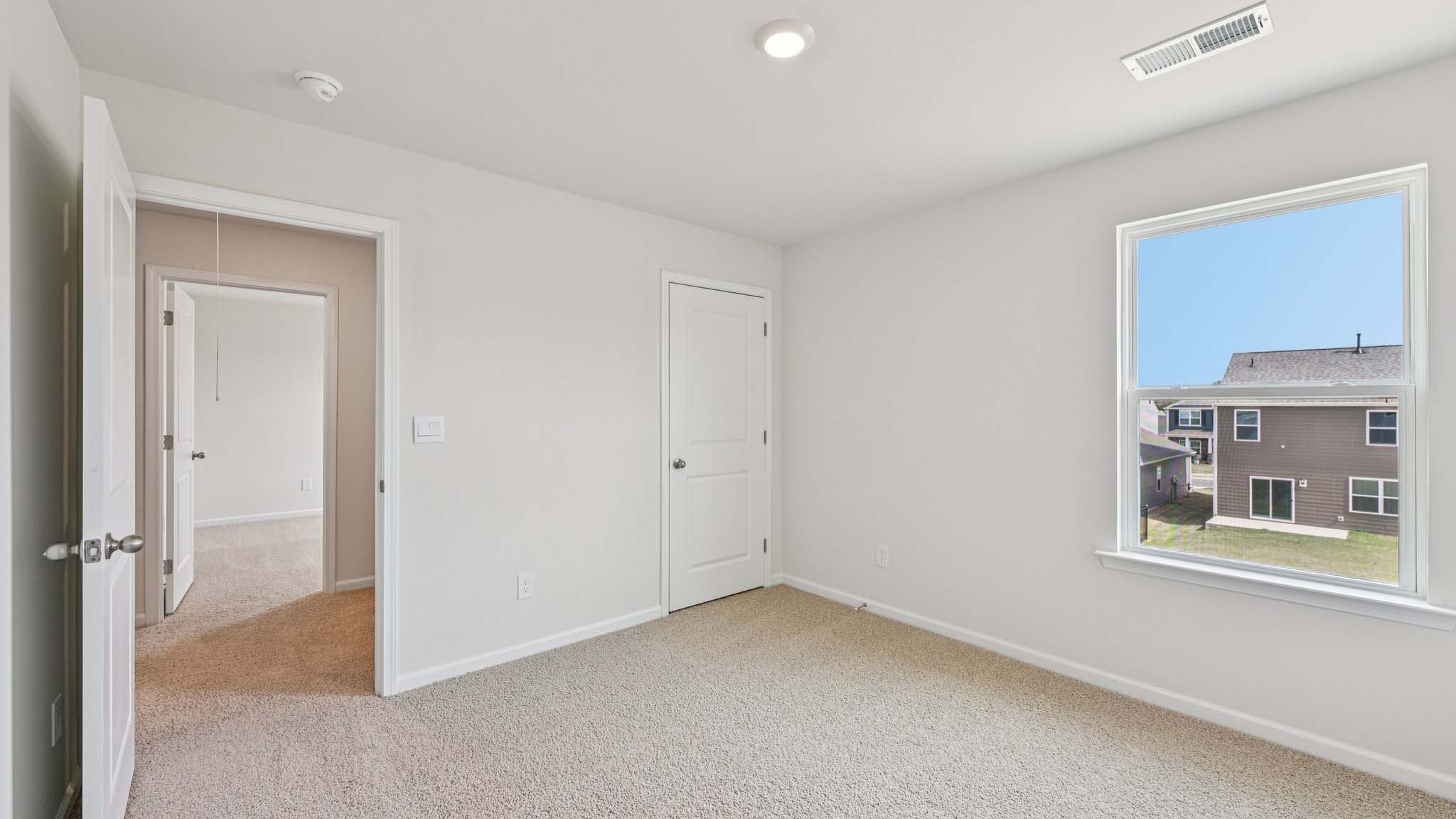 Carpeted bedroom with large window