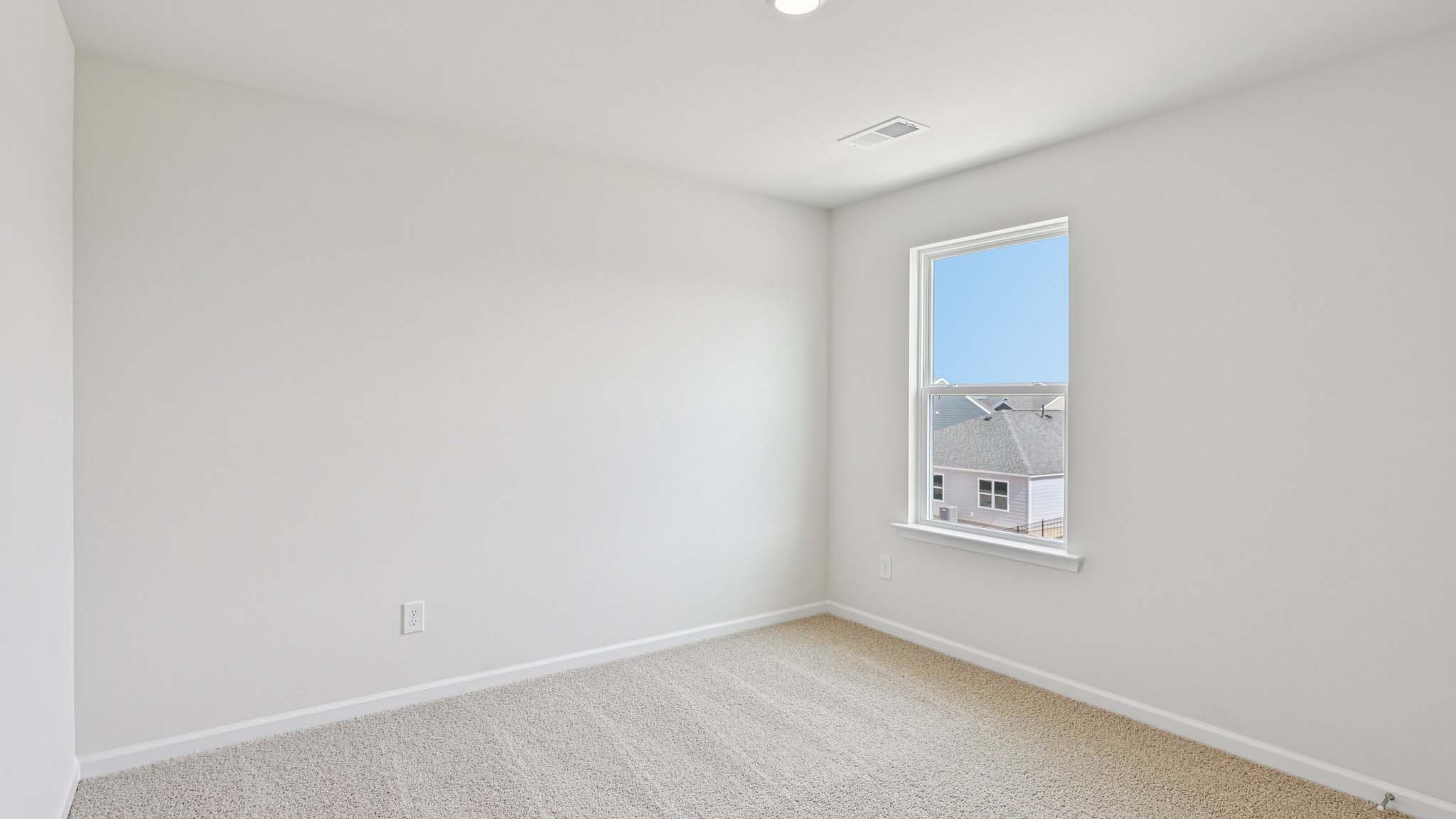 Carpeted bedroom with large window