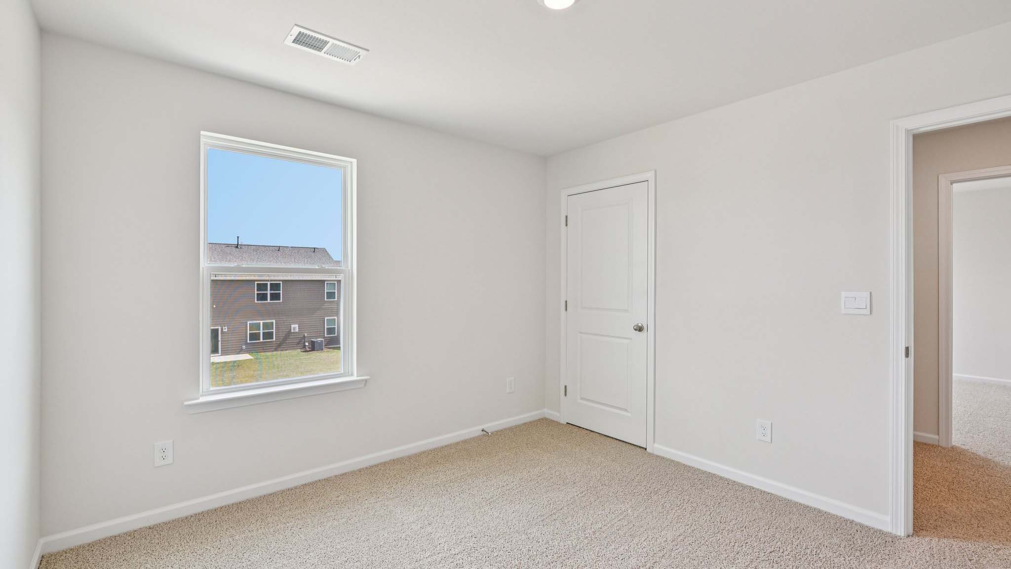 Carpeted bedroom with large window