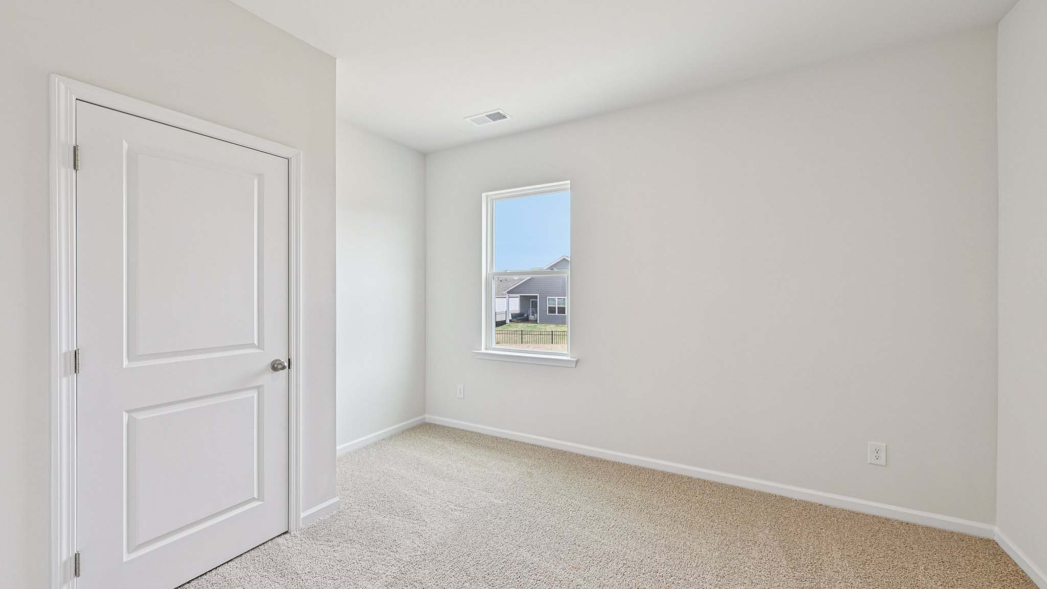 Carpeted bedroom with large window