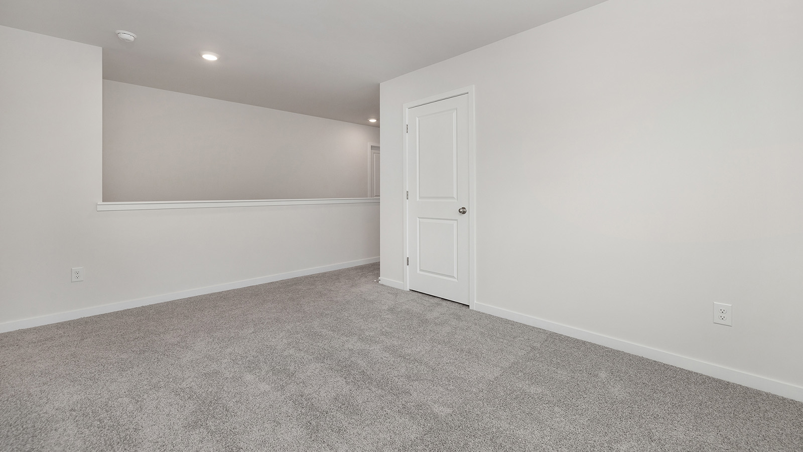 Model primary carpeted bedroom with large window