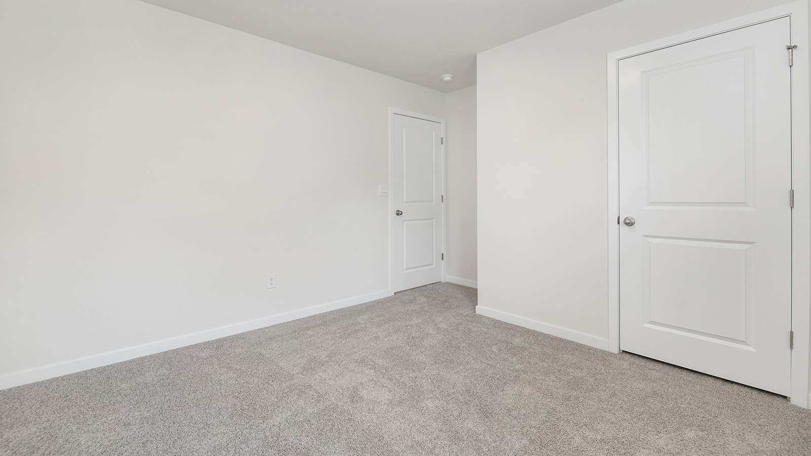 Model carpeted bedroom with small window