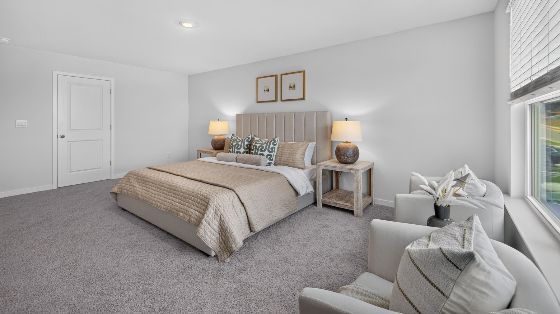 Primary carpeted bedroom with large windows