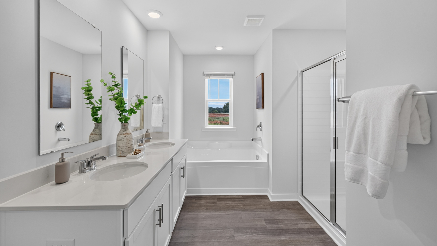 Primary bathroom with double sinks and standing glass shower