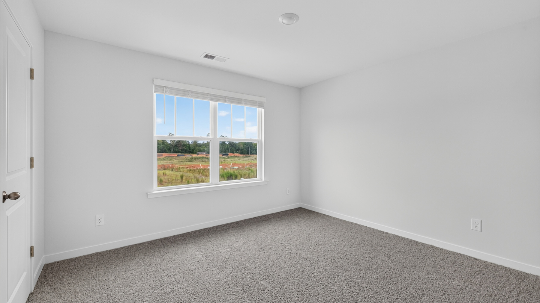 Carpeted bedroom with windows