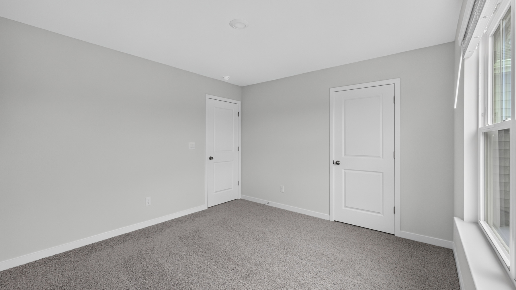 Carpeted bedroom with windows