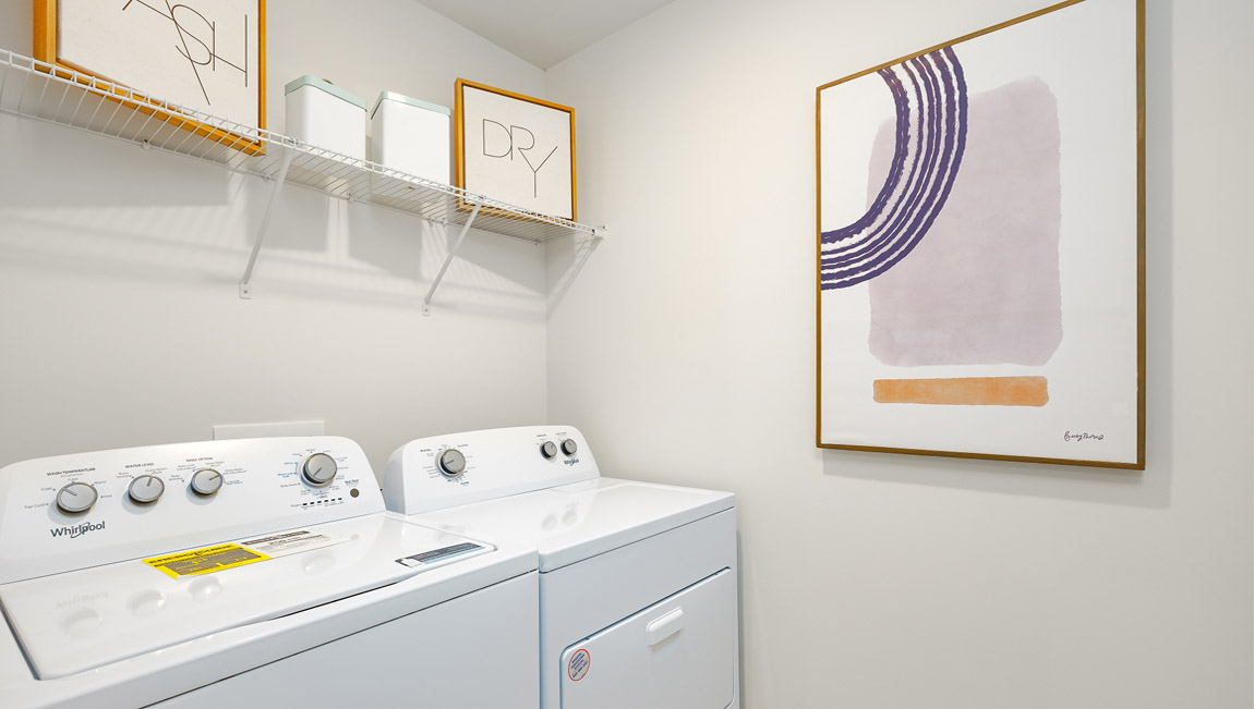 Model laundry room with rack above machines