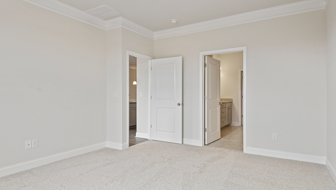 Primary bedroom, carpeted floors, large windows
