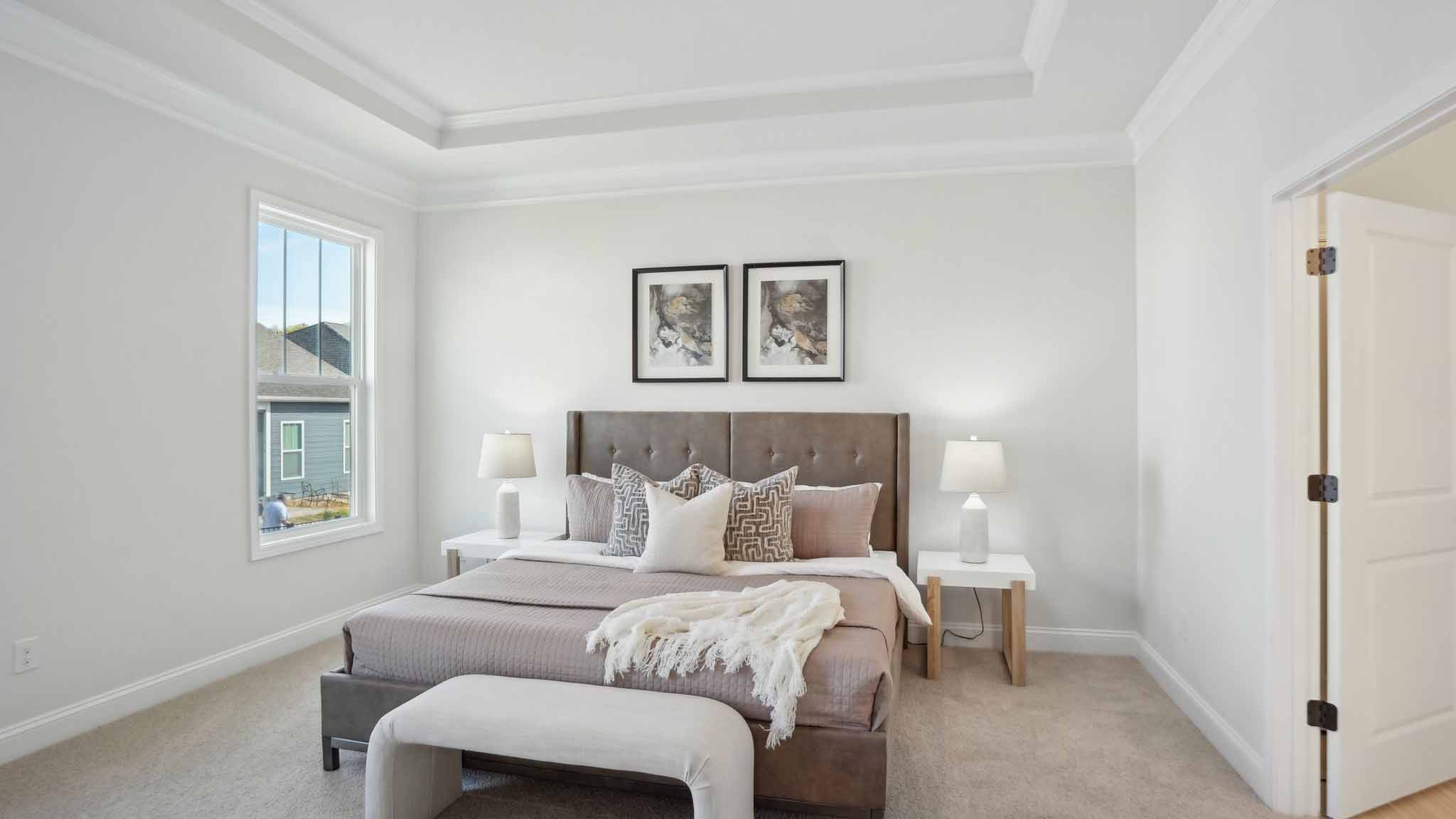 Primary bedroom with wood floors, and two large windows