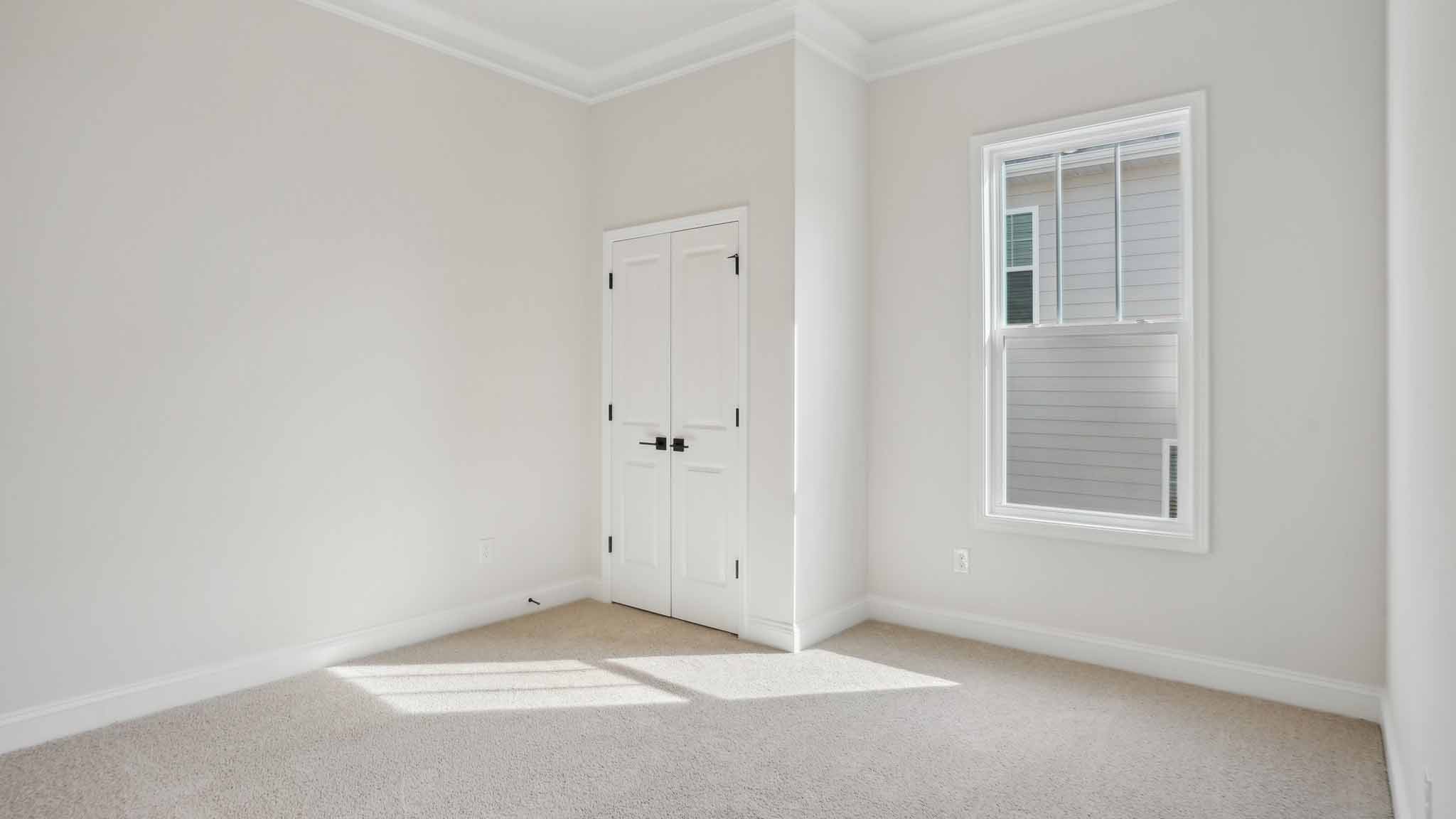 Carpeted bedroom three large windows
