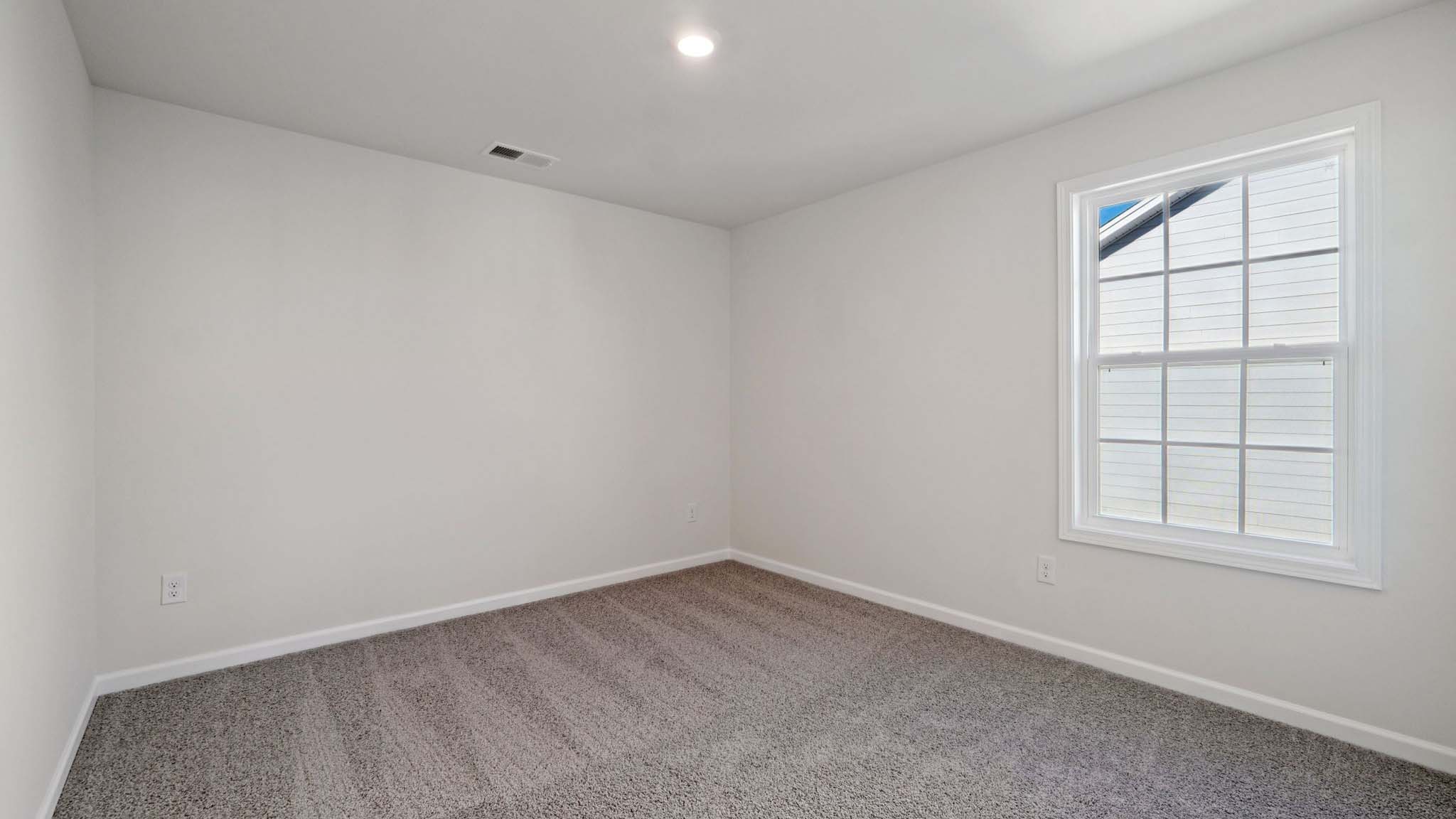 carepeted bedroom with small window