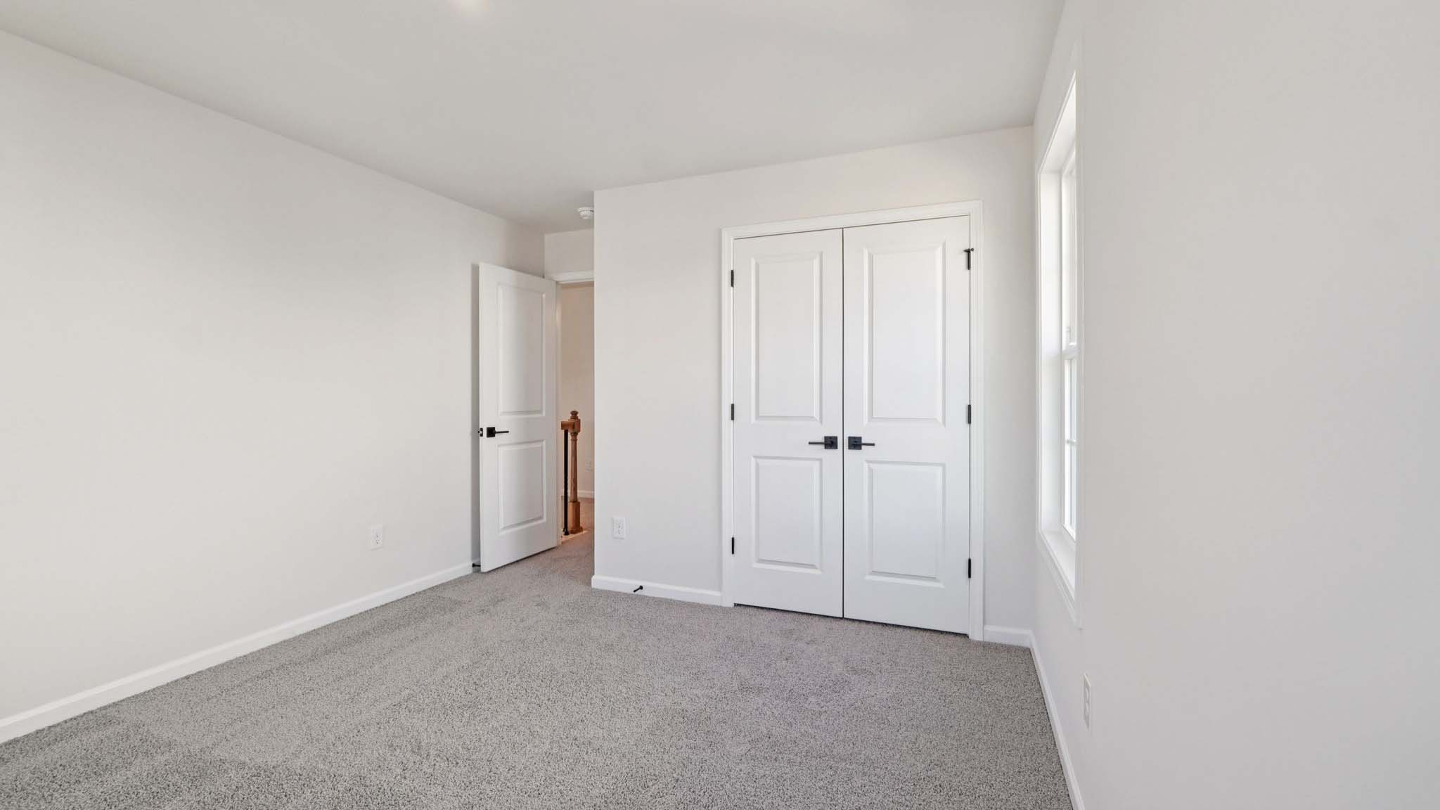 carepeted bedroom with small window