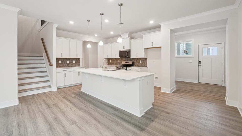Kitchen and island, white counters and cabinets, wood floors