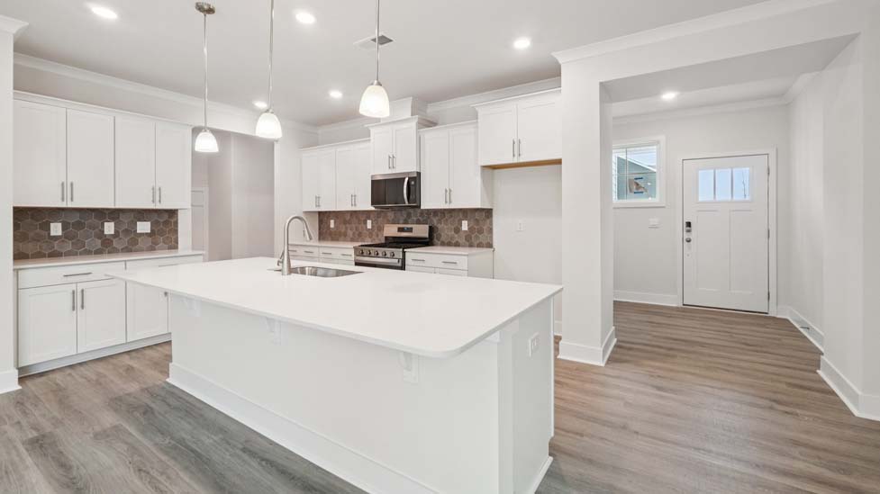Kitchen and island, white counters and cabinets, wood floors