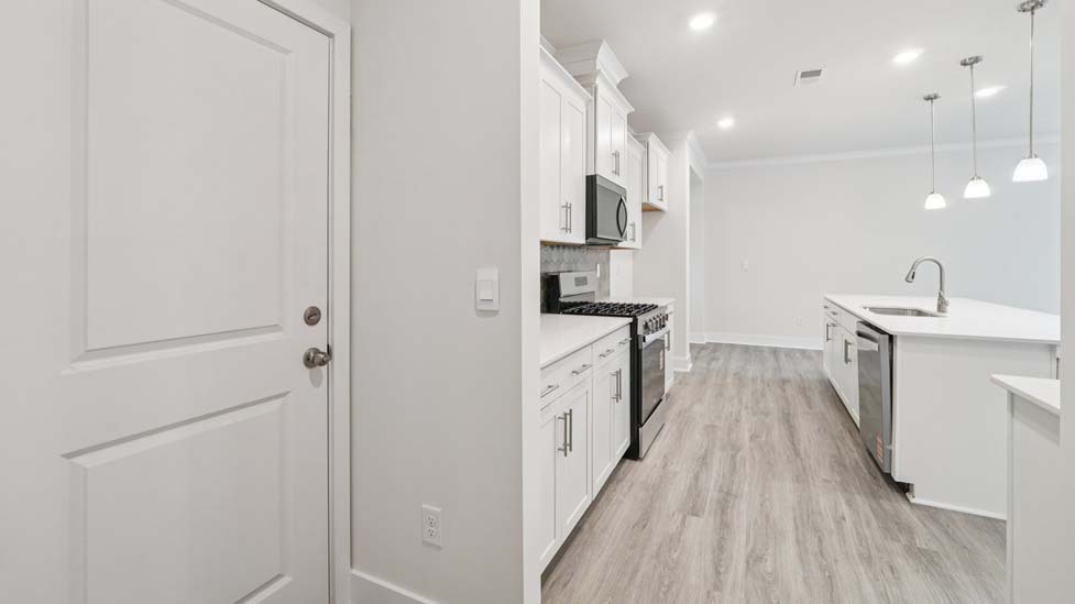 Kitchen and island, white counters and cabinets, wood floors