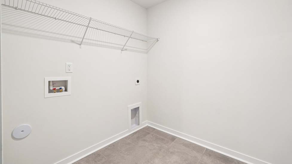 Laundry room with built in racks above machines