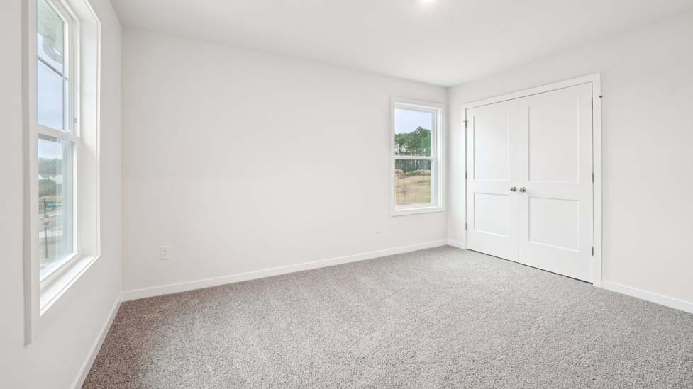 Carpeted bedroom with two windows