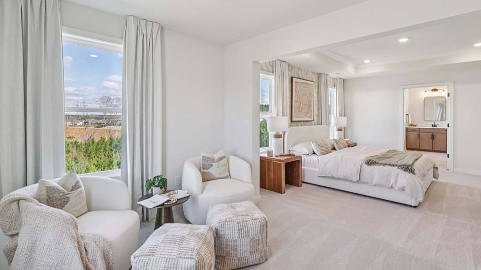 Primary bedroom with beige carpet, ceiling fan and large window