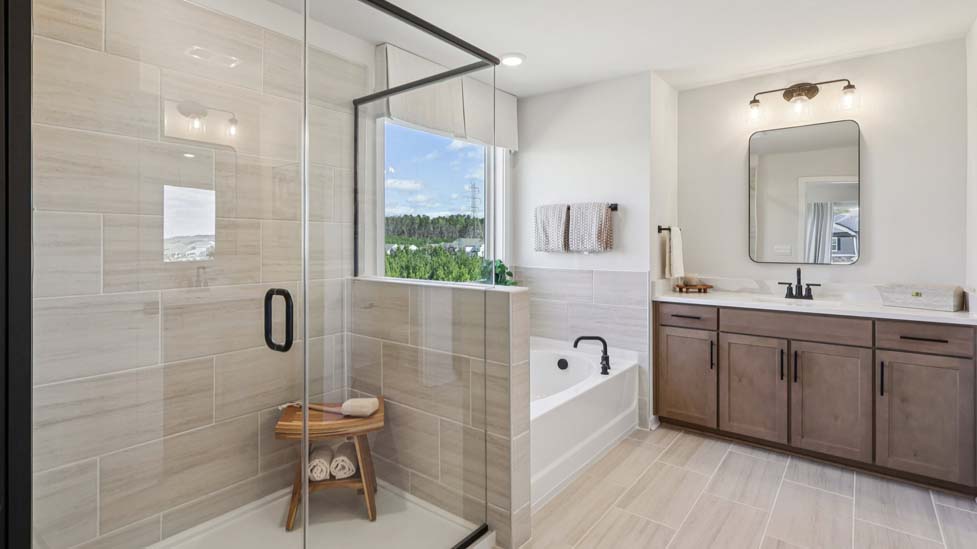 Primary bathroom with soaking tub, dual vanity, and glass door shower